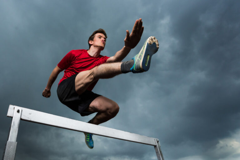 Athlete jumping over a hurdle
