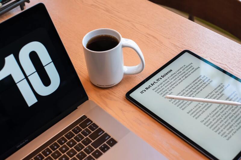 Tablet, laptop, and coffee mug on a table