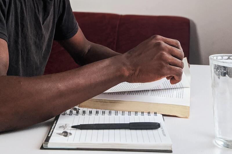 Student reading a book on a desk