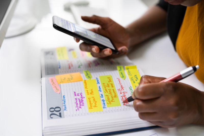 Student marking a schedule on a diary