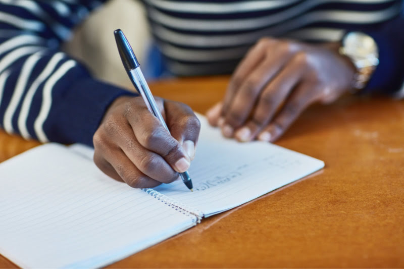 Student writing on a notebook