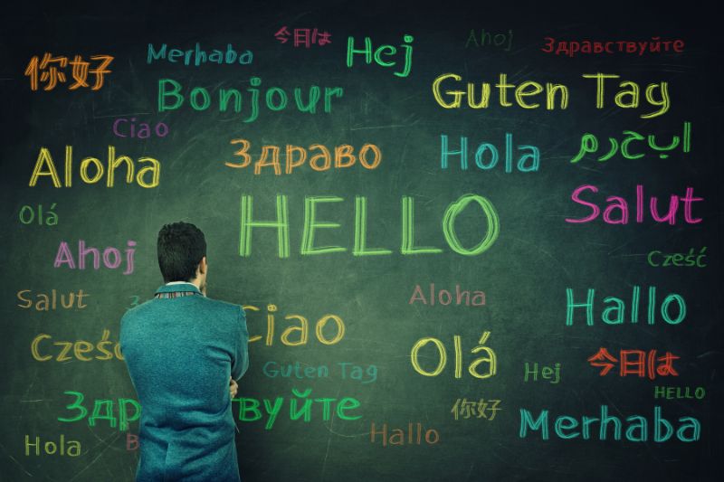 Multiple language greetings scribbled on a chalkboard