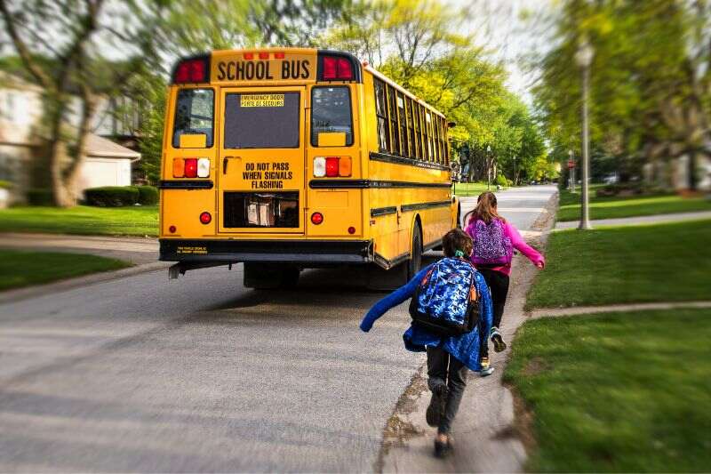Children running towards a school bus
